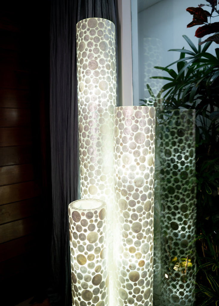Beautiful set of 3 differently sized White Coin cylinder floor lamps. The details of the white coin design are visible.