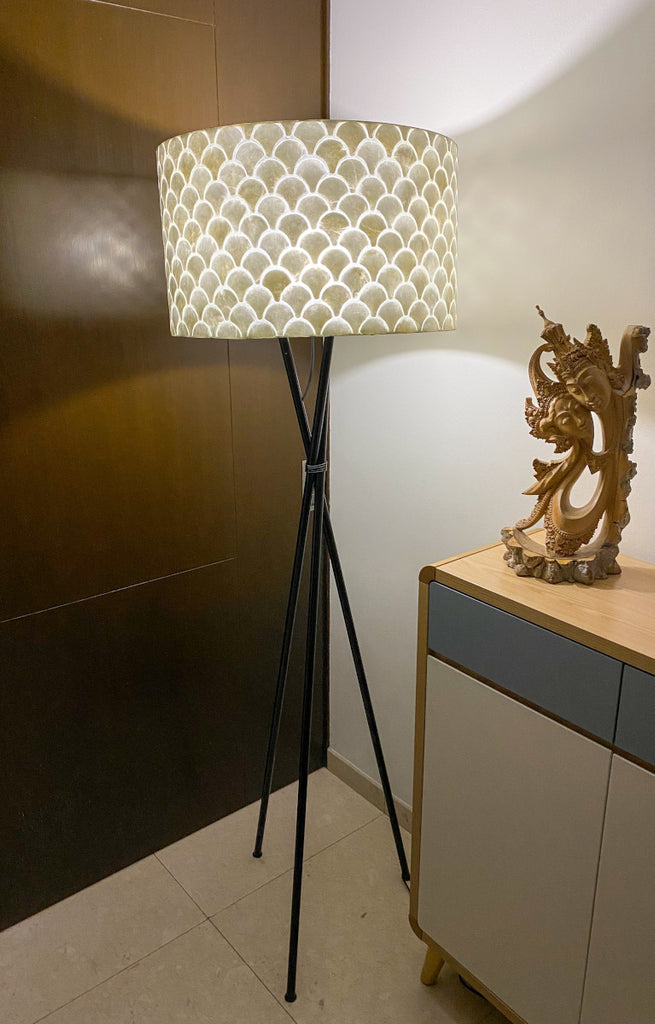 Kipas Floor Lamp with Shade in a living room infront a wooden wall. Very Nice design of the shade fits to many interior designs