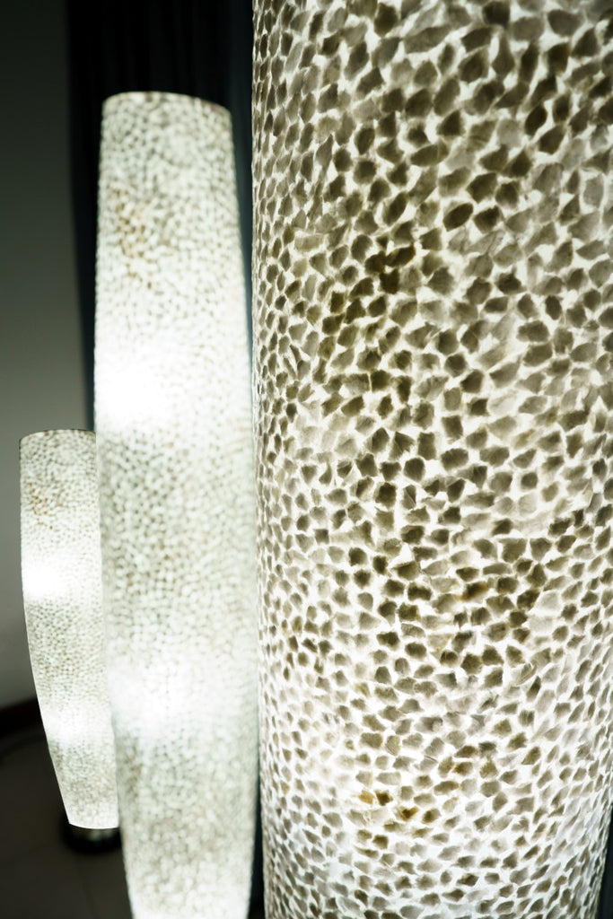 3 Illuminated Wangi White Apollo Floor Lamps standing in front of a curtain. The beautiful Wangi White Design is visible on this image