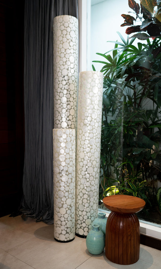 Beautiful set of 3 differently sized White Coin cylinder floor lamps. The details of the white coin design are visible.