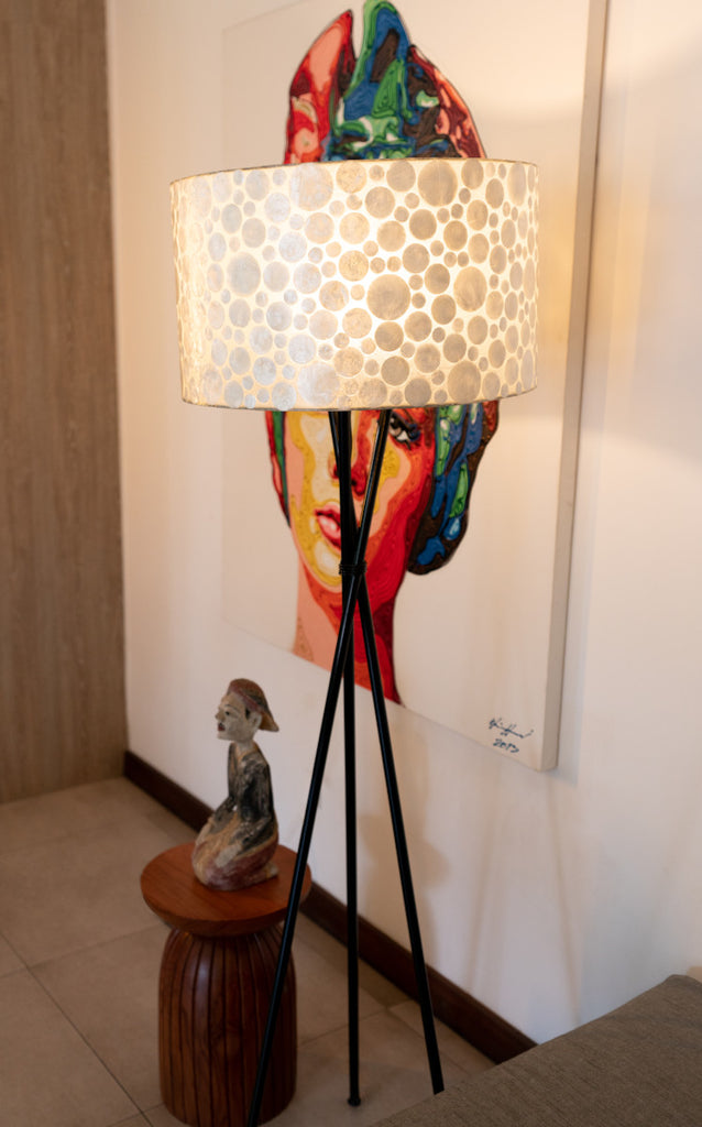 White Coin Tripod Floor Lamp with shade in front a picture. in a living room. LHD – Lighting in Singapore