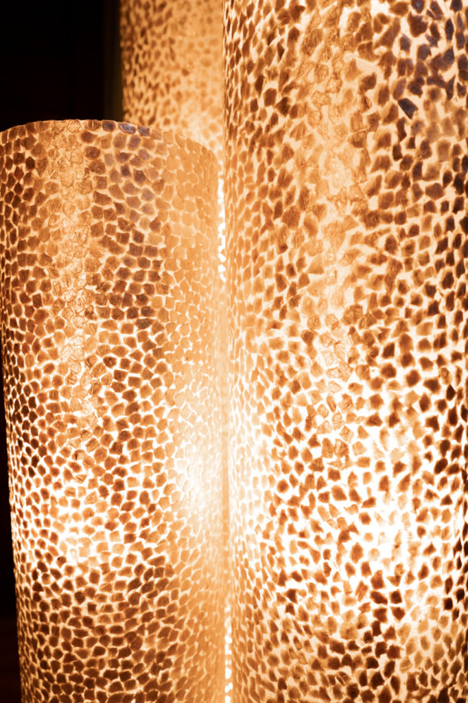 A set of illuminated Wangi Gold floor lamps from Light House Design in a tropical environment. Details of the lamp design are shown on this pic. Light House Design - decorative Lighting in Singapore