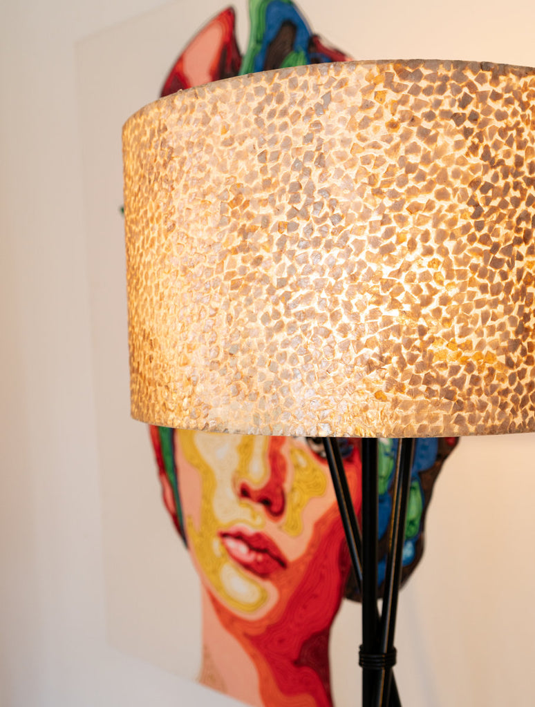 Wangi Gold Floor lamp with shade standing next to a colorful picture in a Balinese villa in Indonesia. Design Detils of the Wangii Gold Design are visible on this picture