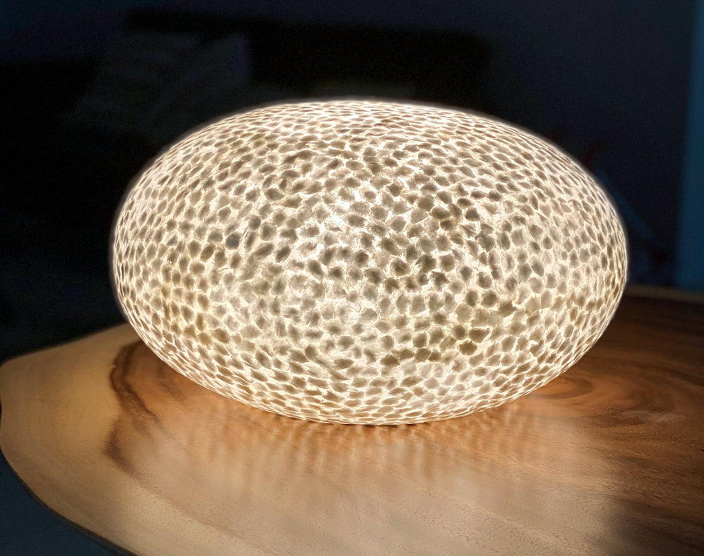 Table Lamp Wangi White Ufo on a table in the dark with reflecting light