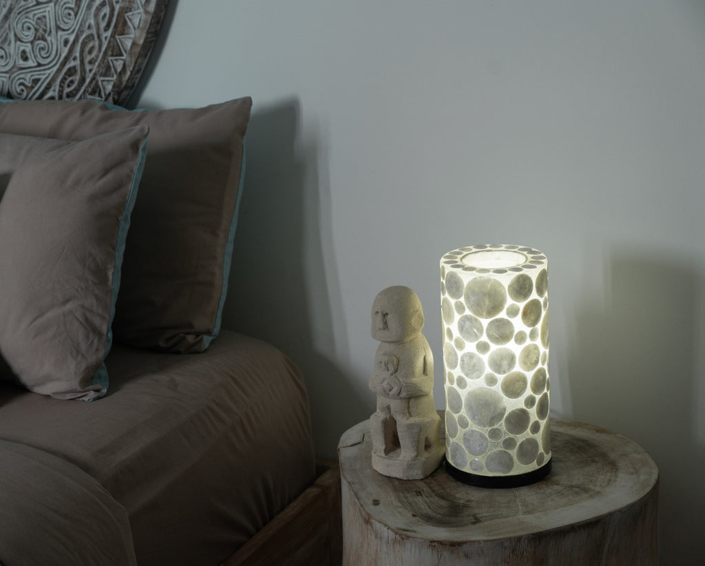 Table Lamp "White Coin Mini Cylinder" standing on a bedside table in a bedroom.