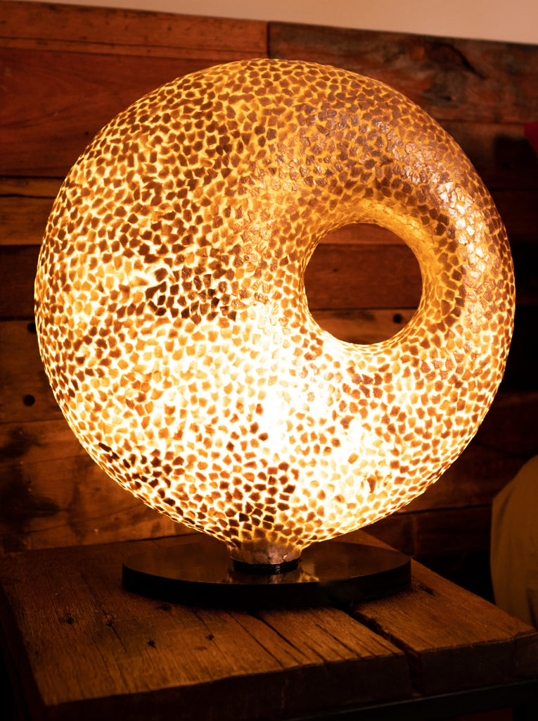 Illuminated Floor Lamp Wangi Gold Doughnut in a bed room with wooden furniture. This is a handcrafted Light House Design Statement Lamp