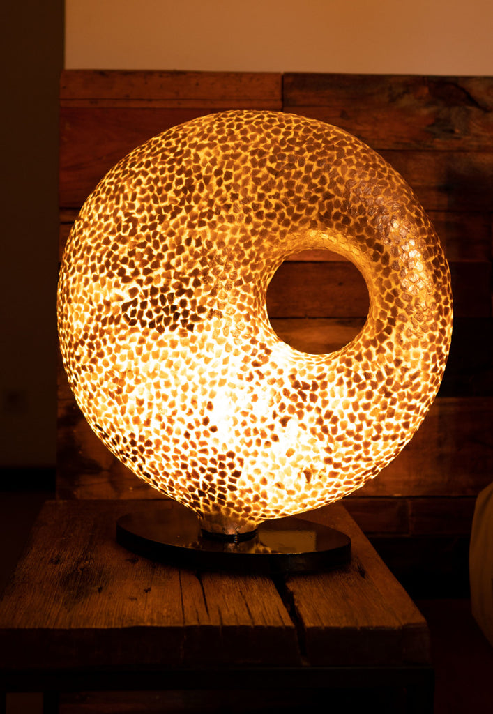 Illuminated Floor Lamp Wangi Gold Doughnut in a bed room with wooden furniture. This is a handcrafted Light House Design Statement Lamp