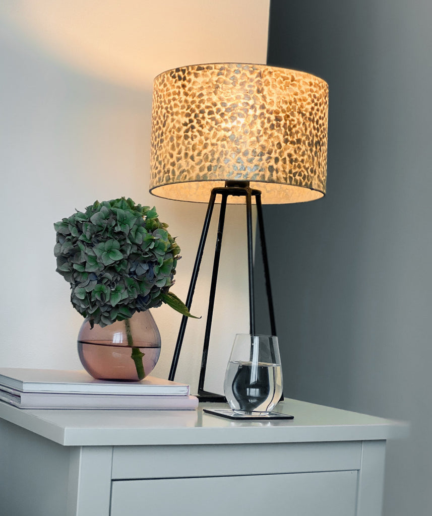 Wangi Gold Table Lamp with Shade on a bedside table in a bedroom next to the bed
