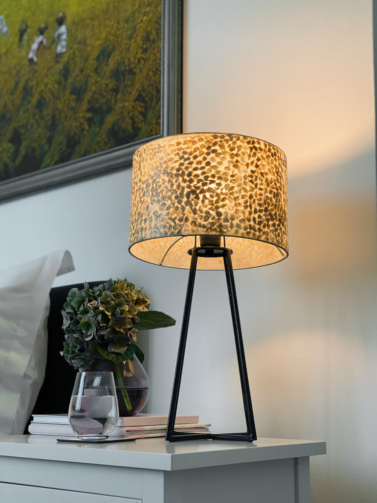 Wangi Gold Table Lamp with Shade on a bedside table in a bedroom next to the bed